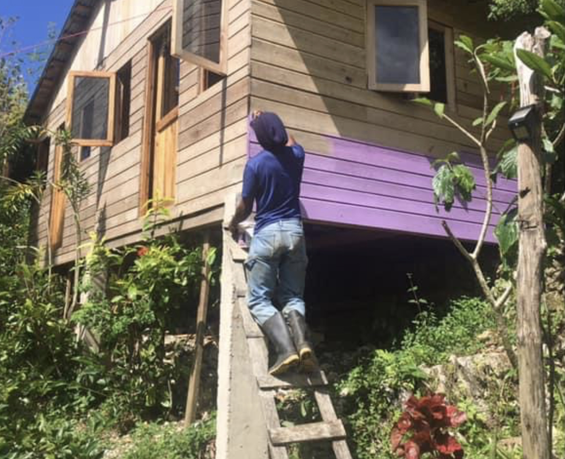 Painting one of the cabins, our community is everything at Mel's Botanical Retreat